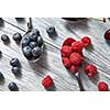 Delicious sweet berries on a spoon gray wooden background. Flat lay. Concept of vegetarian eating.
