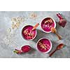 Superfoods red smoothie bowl with beetroot, oat flakes and raspberries on stone background, flat lay