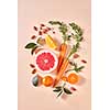 Carrot, slices of orange and grapefruit, almond, mandarins, green leaf - on a paper background. Concept of colorful organic food. Flat lay