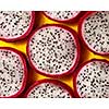 Top view of tropical exotic cut round slices of Dragon fruit or Pitaya on a yellow background. Close-up view.