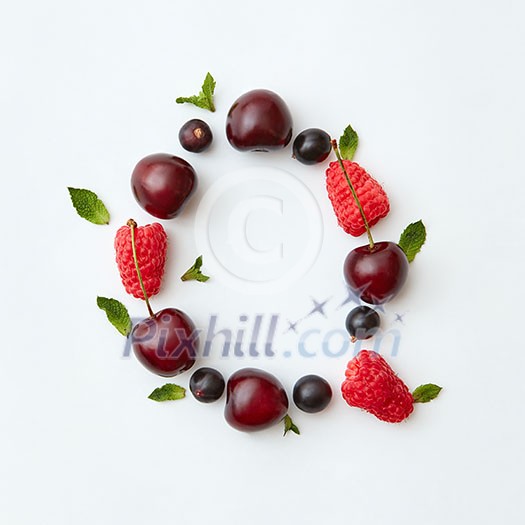 Letter Q english alphabet in the form of a pattern of natural organic berries - ripe fresh raspberry, black currant, cherry, green mint leaf isolated on a white background. Top view.