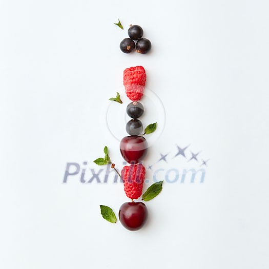 Letter I english alphabet in the form of a pattern of natural organic berries - ripe fresh raspberry, black currant, cherry, green mint leaf isolated on a white background. Top view.