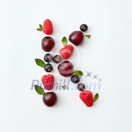 Letter K english alphabet in the form of a pattern of natural organic berries - ripe fresh raspberry, black currant, cherry, green mint leaf isolated on a white background. Flat lay