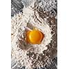 Top view heap of flour with raw egg on a kitchen table. Step-by-step cooking