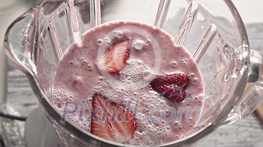 Sharp splash of cocktail from the bowl into table. Preparation of helathy organic milkshake, smoothies from strawberries, milk cream, chia seeds. Top view. Full HD video,240fps,1080p. Slow motion.