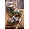 Herring sandwich (traditional Danish smorrebrod) on cutting board.