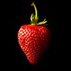 Ripe red strawberries on a black background. Shallow depth of field.