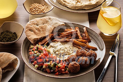 Traditional falafel balls with salad and hummus on a plate. Traditional falafel balls with salad and hummus on a plate.