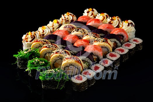 Fresh Sushi rolls set served on black background. Japanese seafood sushi.