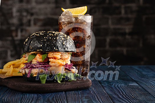Black burger with fish and shrimps. Fishburger with prawns and French Fries. Black burger with fish and shrimps. Fishburger with prawns and French Fries.