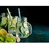 Fresh Summer Drink. Healthy detox fizzy water with lemon and cucumber in mason jar over dark background. Healthy food concept. Detox diet.