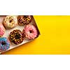 Variety of colorful tasty glazed donuts on a colored background.