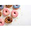 Variety of colorful tasty glazed donuts on a white background.