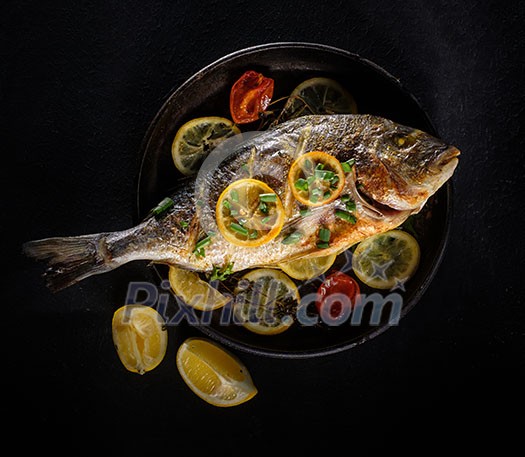 Grilled Dorado with lemon, thyme and rosemary over black background Grilled Dorado with lemon, thyme and rosemary over black background