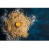 Dried egg noodles. Raw Fresh Spaghetti on blue wooden background.