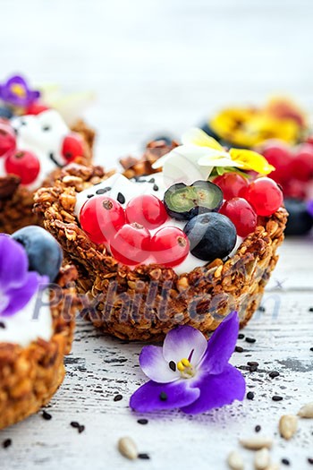 Dessert with sunflower seeds, yogurt and fresh berries on white wooden background