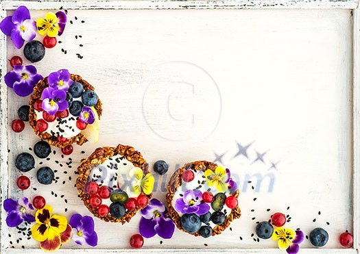 Dessert with sunflower seeds, yogurt and fresh berries on white wooden background