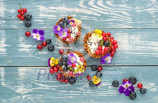 Dessert with sunflower seeds, yogurt and fresh berries on blue wooden table