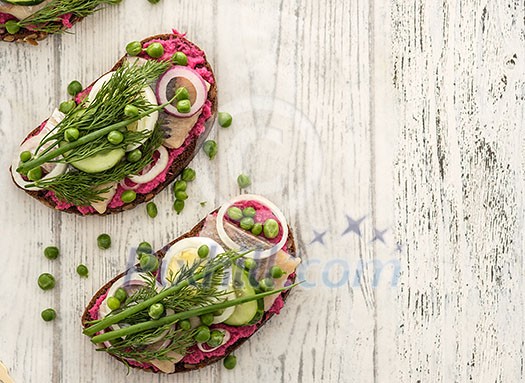 Sandwich with herring, horseradish and fresh herbs. Top view.