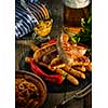 Grilled sausages and stewed cabbage with a mug of beer on a wooden table. Rustic style. Snacks for the Oktoberfest.