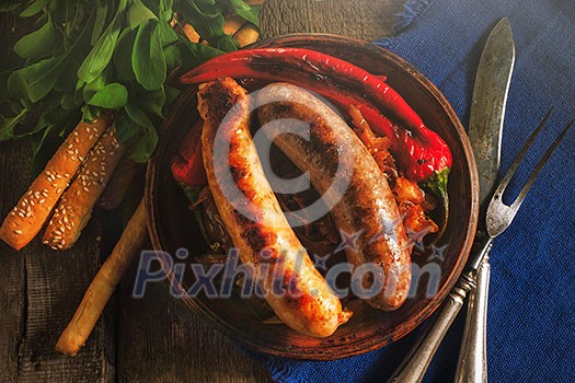 Grilled sausages and stewed cabbage on a wooden table. Rustic style. Snacks for the Oktoberfest. Top view.