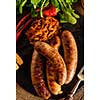 Grilled sausages and stewed cabbage with a mug of beer on a wooden table. Rustic style. Snacks for the Oktoberfest. Top view.