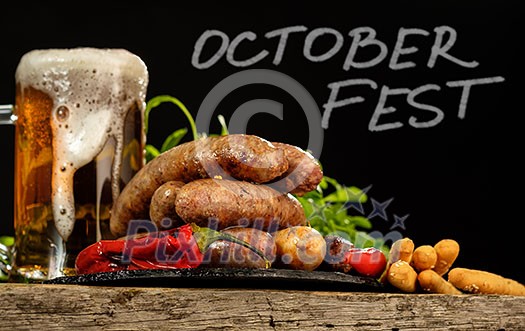 Grilled sausages with a glass of beer on a wooden table. Rustic style. Snacks for the Oktoberfest.