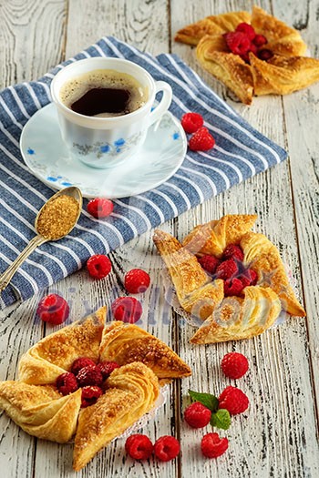 Tasty fresh homemade puff pastry with berries on the white wooden table.