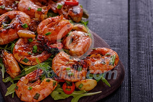 Large grilled BBQ shrimp with sweet chili sauce, green onion and lemon. Copyspace.