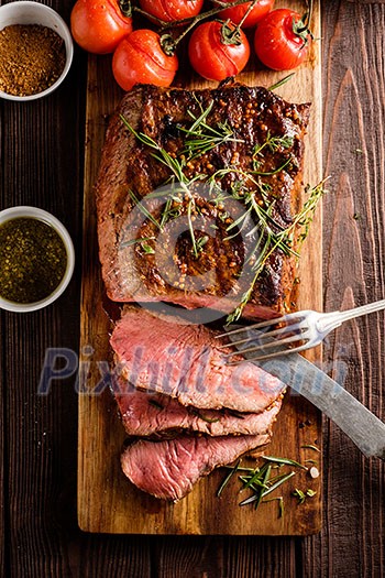 Sliced Roast beef on cutting board with grilled vegetables. Top view. Sliced Roast beef on cutting board with grilled vegetables. Top view.