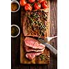 Sliced Roast beef on cutting board with grilled vegetables. Top view.