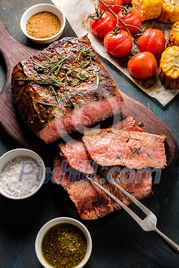 Sliced Roast beef on cutting board with grilled vegetables. Top view. Sliced Roast beef on cutting board with grilled vegetables. Top view.
