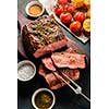 Sliced Roast beef on cutting board with grilled vegetables. Top view.