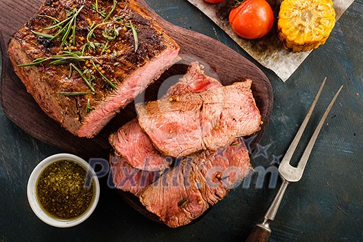 Sliced Roast beef on cutting board with grilled vegetables. Top view. Sliced Roast beef on cutting board with grilled vegetables. Top view.