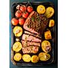 Sliced Roast beef on iron tray with grilled vegetables, top view