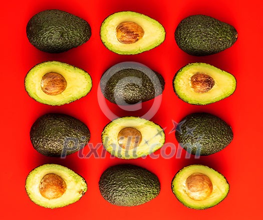  Avocado on the red background. Pattern with avocado. Abstract background.