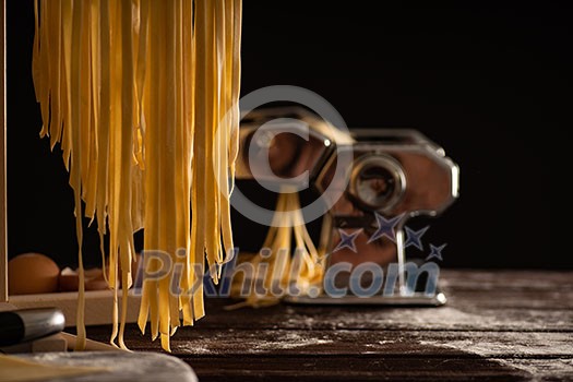 Freshly prepared Tagliatelle paste is dried on a wooden drier. Traditional italian cuisine. Freshly prepared Tagliatelle paste is dried on a wooden drier. Traditional italian cuisine.