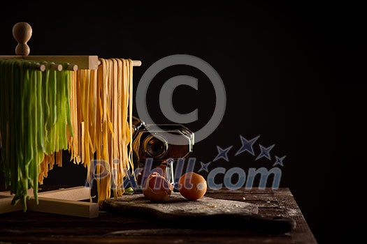 Freshly prepared Tagliatelle paste is dried on a wooden drier. Traditional italian cuisine. Freshly prepared Tagliatelle paste is dried on a wooden drier. Traditional italian cuisine.