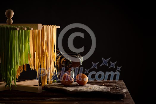 Freshly prepared Tagliatelle paste is dried on a wooden drier. Traditional italian cuisine.