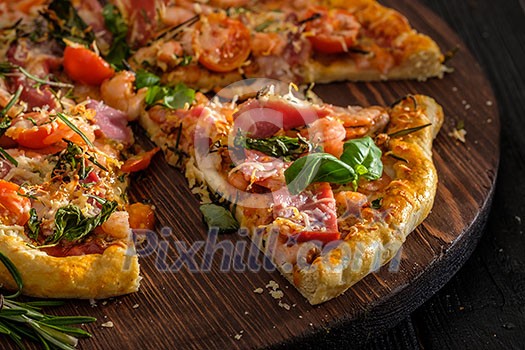 Delicious homemade fresh pizza with shrimps and bacon. Close-up.