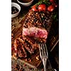 Sliced Roast beef on cutting board with grilled vegetables 