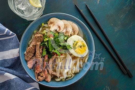 Asian ramen soup with beef, egg, chives, mushrooms in bowl