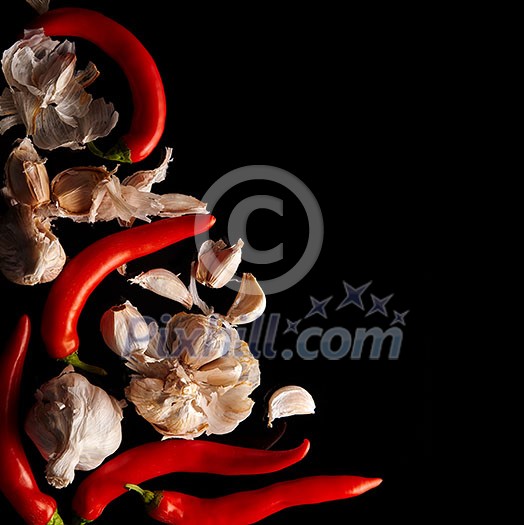 Garlic and red pepper on a black surface, top view. Garlic and red pepper on a black surface, top view.