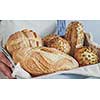 Bread assortment in the hands of the baker, horizontal banner, close-up.