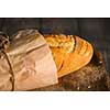 A fresh baguette on a wooden surface. Shallow depth of field.