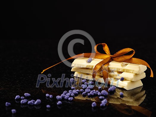 Pieces of white chocolate on dark marble. Postcard concept. Pieces of white chocolate on dark marble. Postcard concept.