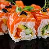 Close-up of traditional japanese sushi on a dark background with reflection. Salmon with shrimp and red caviar