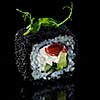 Close-up of traditional japanese sushi on a dark background with reflection. Salmon with Philadelphia cheese and black caviar
