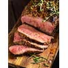 Sliced Roast beef on cutting board with grilled vegetables 