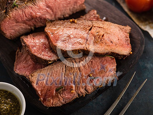 Sliced Roast beef on cutting board with grilled vegetables Sliced Roast beef on cutting board with grilled vegetables